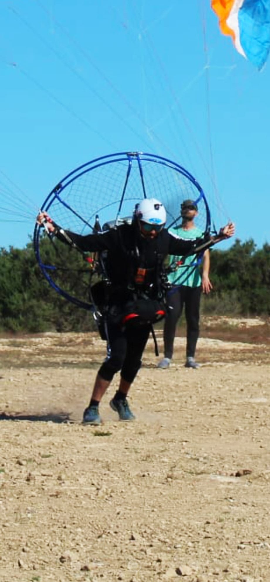 Socio del club despegando a pie con paramotor de mochila