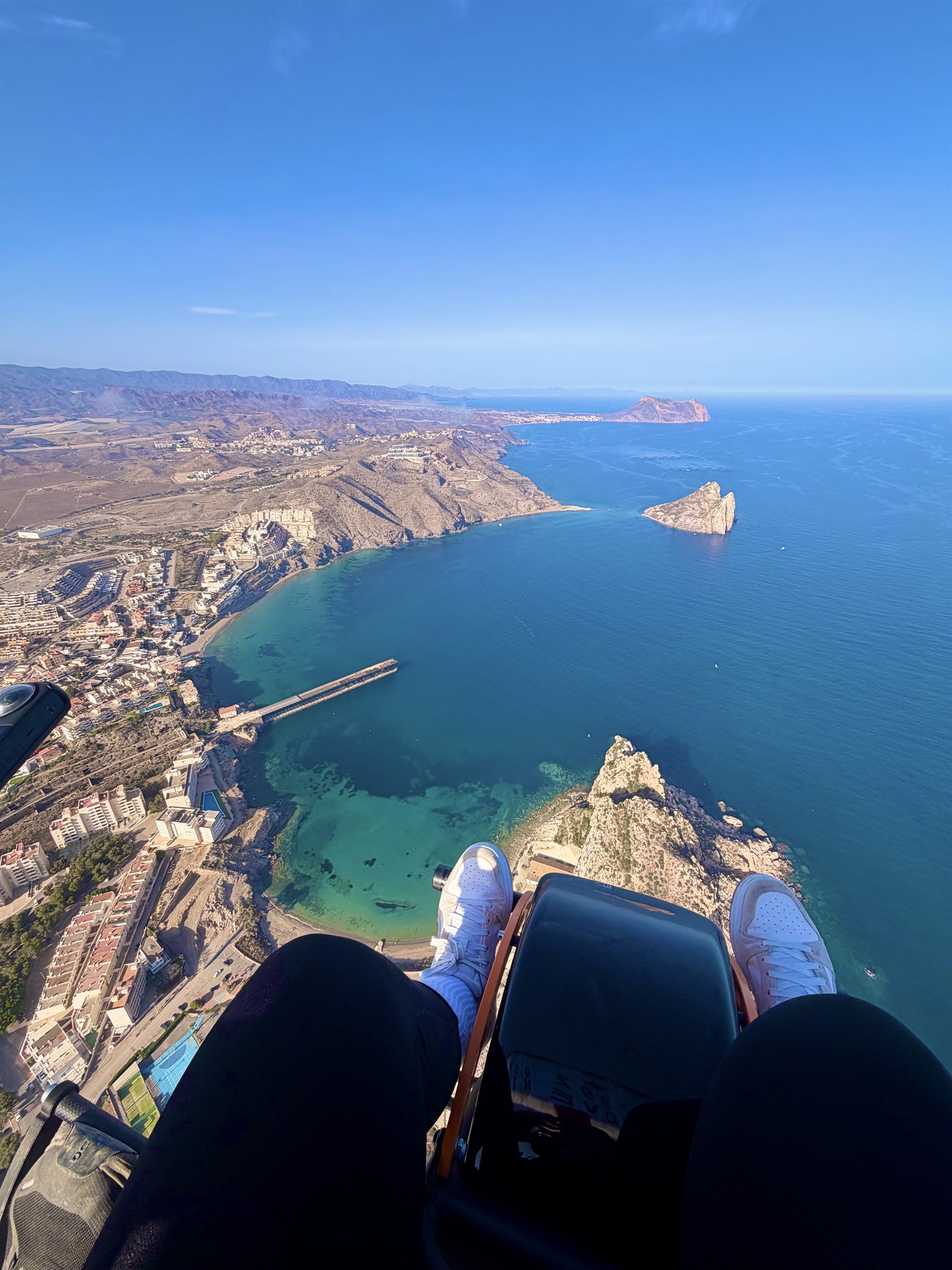 Vista desde el paramotor sobre la costa de Águilas: la cala, la Isla del Fraile y, abajo, los pies del pasajero