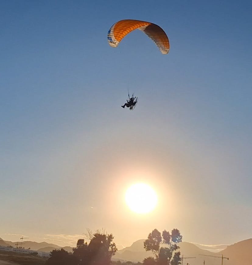 Paramotor a contraluz justo encima del sol
